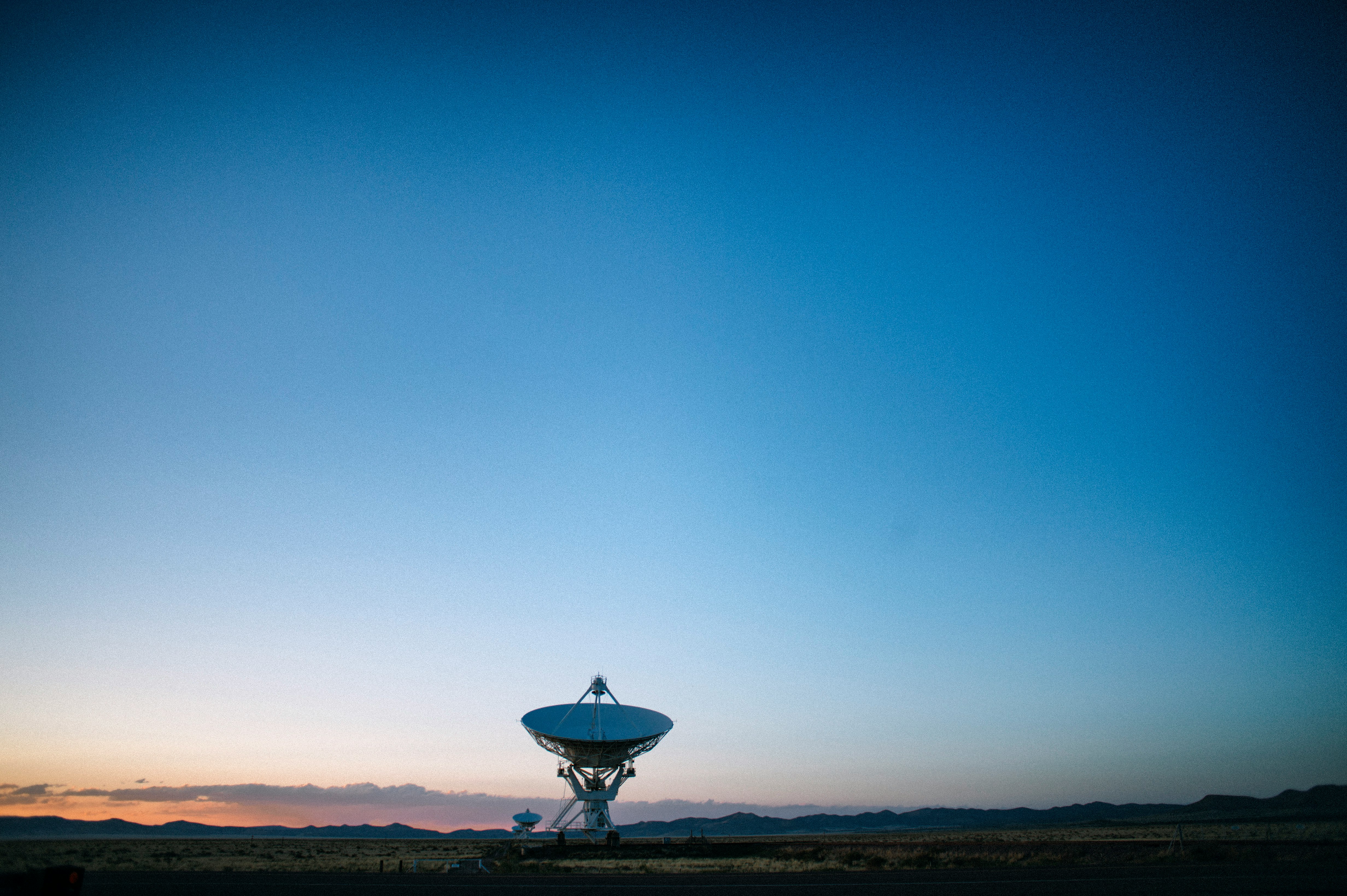 white satellite dish on brown field under blue sky during daytime